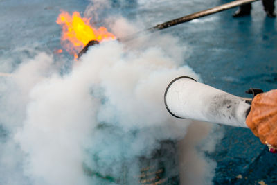 Midsection of man holding fire against blurred background