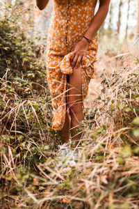 Low section of woman standing on field