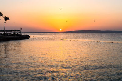 Scenic view of sea against orange sky