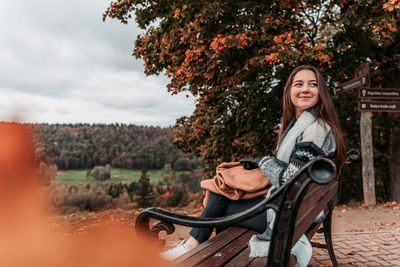 Portrait of a smiling young woman sitting outdoors