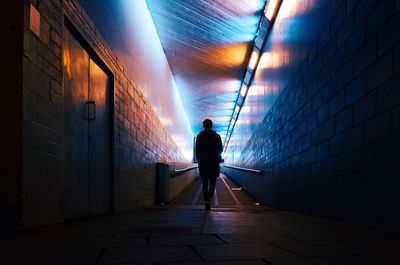 Rear view of silhouette man walking in corridor