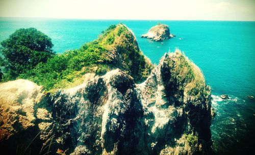 High angle view of rocks by sea against sky