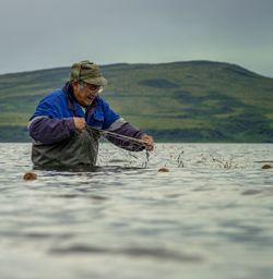 Man holding fishing net in lake