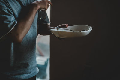 Midsection of man holding plate