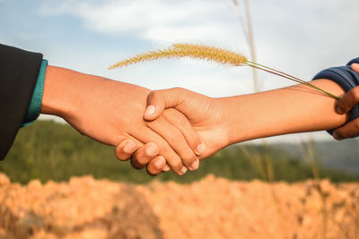 Midsection of couple holding hands