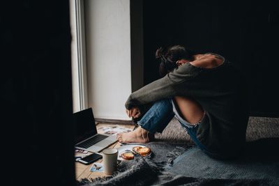 Side view of woman using mobile phone at home