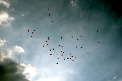 Low angle view of balloons flying against sky