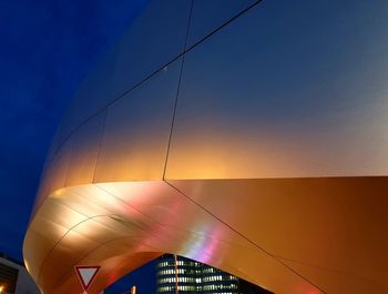 Low angle view of illuminated building against sky during sunset