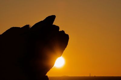 Silhouette man against orange sky during sunset