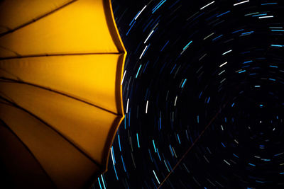 Low angle view of yellow umbrella against star field at night