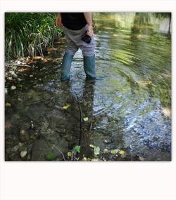 Low section of man standing in water