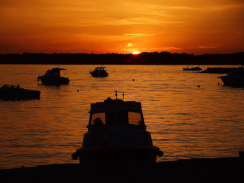 Silhouette of boat in sea at sunset