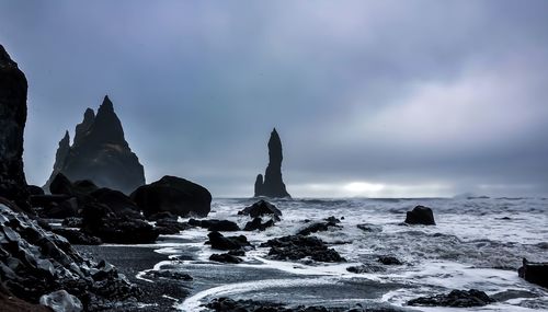 Rocks on beach against sky