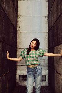 Full length of woman standing against wall