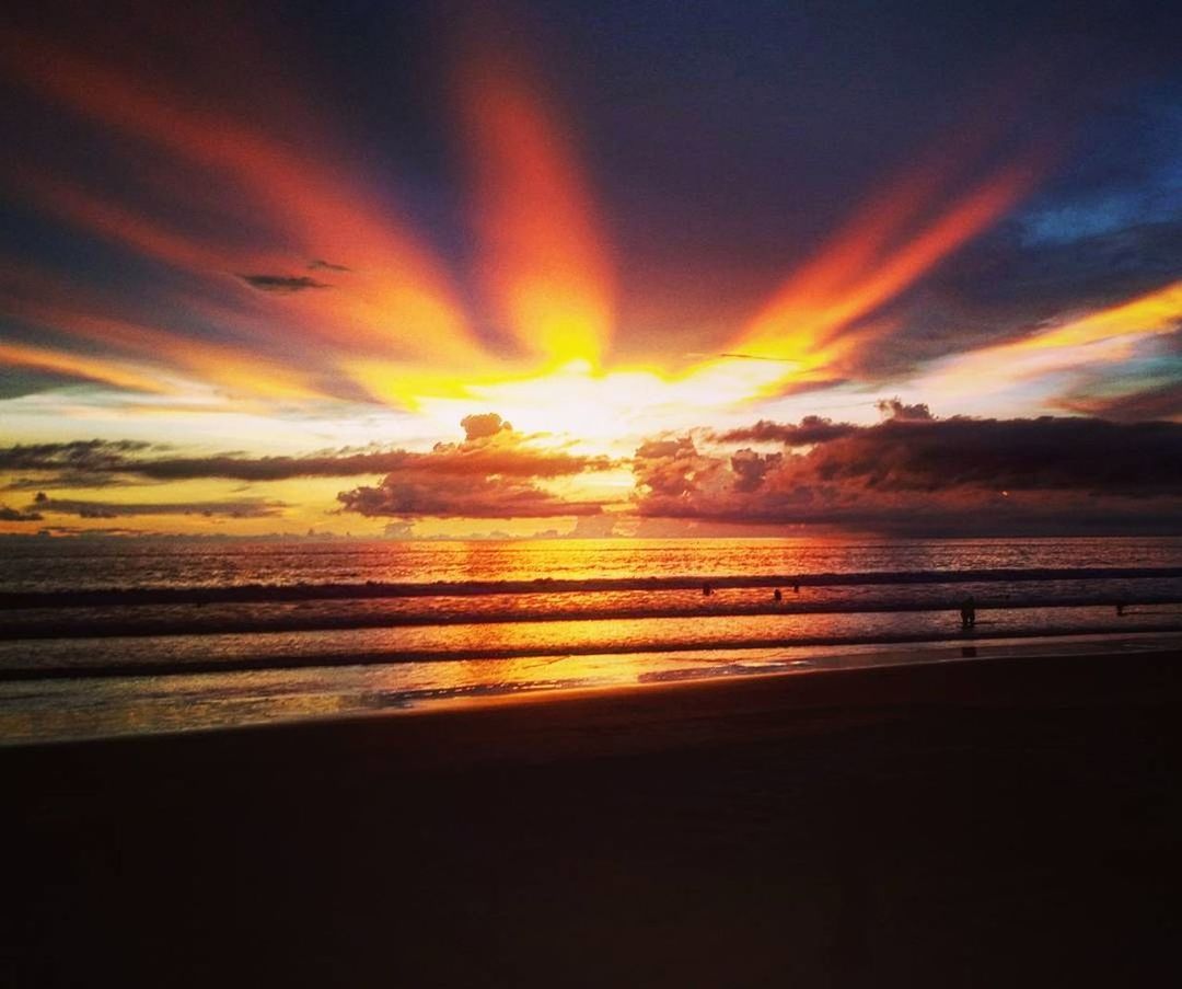 SCENIC VIEW OF BEACH AGAINST ORANGE SKY