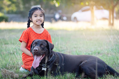 Portrait of woman with dog on field