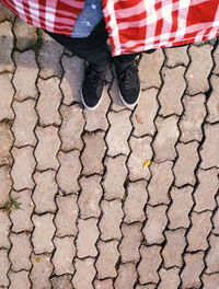 Low section of man standing on cobblestone