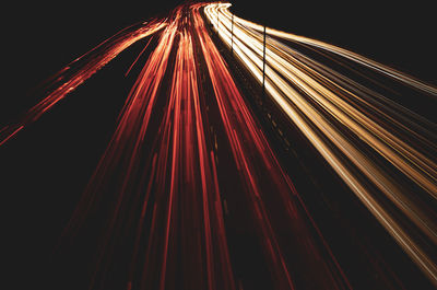 Light trails on road against sky at night