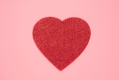 Close-up of heart shape over pink background