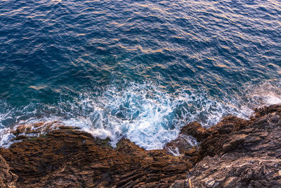 High angle view of waves breaking on rocks