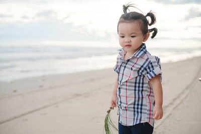 Cute boy standing on beach