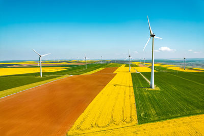 Windmills on field against sky