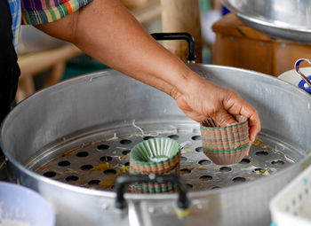 Close-up of mans hand preparing food in kitchen at home