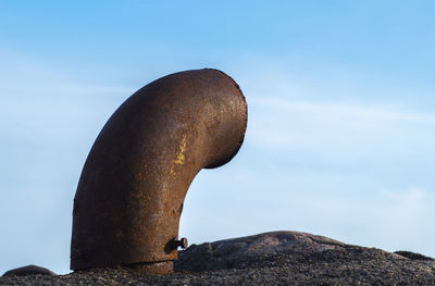 Low angle view of pipe against blue sky