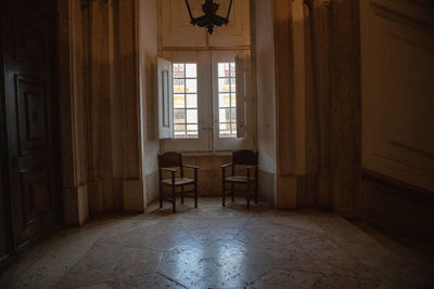 Empty chairs and tables in window of house