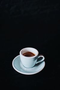 Coffee cup on table against black background