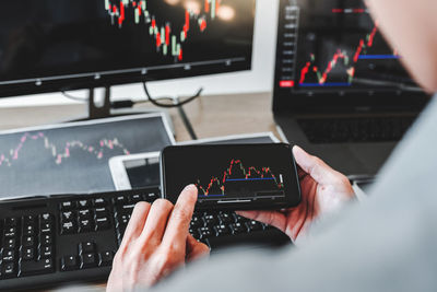 Midsection of man using smart phone at office