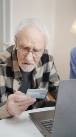 Senior man holding credit card