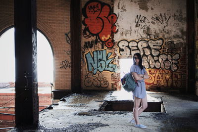 Woman with graffiti on wall