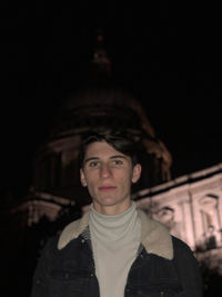 Portrait of young man standing outdoors at night