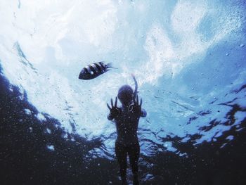 Reflection of man swimming in water