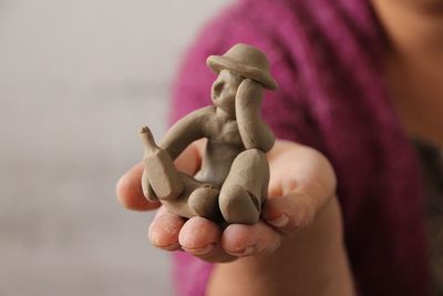 Close-up of human hand holding statue