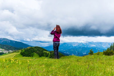 A young female hiker on a break during a hike on a cloudy summer day in the french alps
