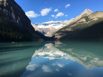 Scenic view of lake by mountains against sky