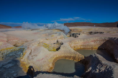 Scenic view of geysers against sky