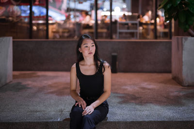 Portrait of young woman sitting outdoors