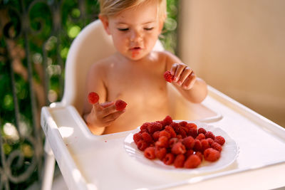 High angle view of boy with fruits in plate