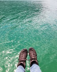 Low section of man sitting over lake