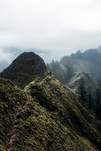 Scenic view of mountains against sky and hiker