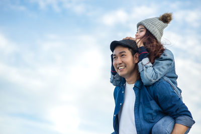 Portrait of a smiling young woman against sky during winter