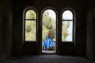 Woman standing by window in building