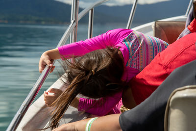 Happy toddler on a boat with family. view from behind. vacation, travel and active kid concept.