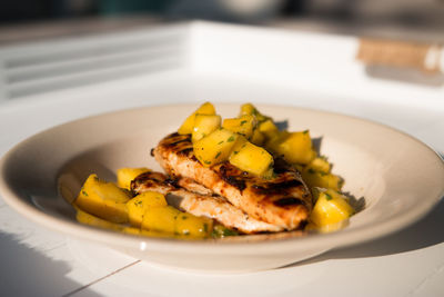 Close-up of meat and mango in plate