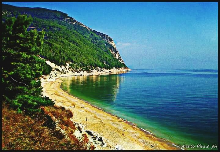 SCENIC VIEW OF SEA WITH MOUNTAIN IN BACKGROUND