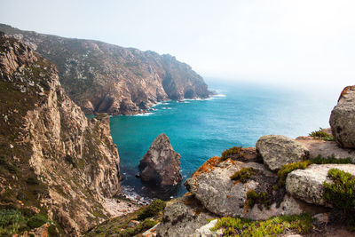 Scenic view of sea and rocks against sky