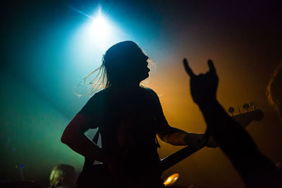 Silhouette people playing guitar at music concert